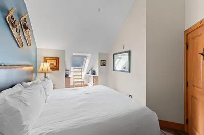 a bedroom with a white bed and a chair at Expedition Station 8633 in Keystone