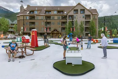 a group of people playing golf in front of a building at Expedition Station 8633 in Keystone