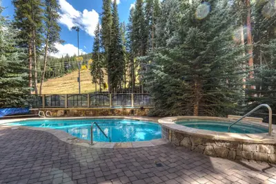 a swimming pool in the middle of a yard with trees at Lone Eagle 3024 in Keystone