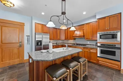 a kitchen with wooden cabinets and a island with bar stools at Lone Eagle 3024 in Keystone