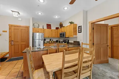 a kitchen with wooden cabinets and a wooden table and chairs at Expedition Station 8553 in Keystone