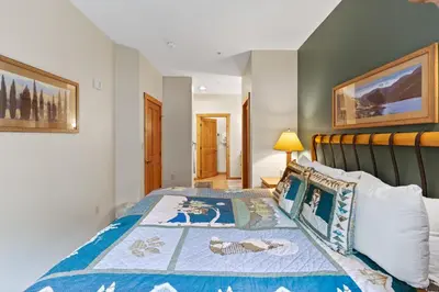 a bedroom with a bed with a blue comforter at Expedition Station 8553 in Keystone