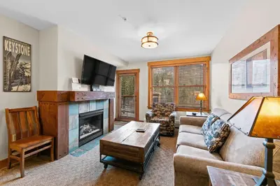 a living room with a couch and a fireplace at Springs 8887 in Keystone