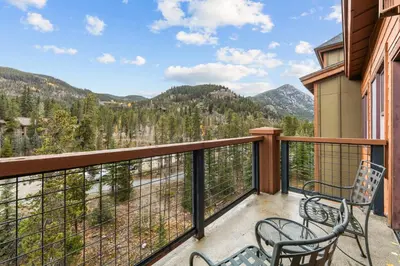 a balcony with two chairs and a view of the mountains at Springs 8887 in Keystone