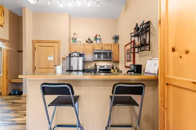a kitchen with two stools at a counter with a microwave at Arap Ldg 8101 in Keystone