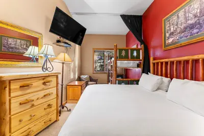 a bedroom with a bed and a dresser with a television at Arap Ldg 8101 in Keystone