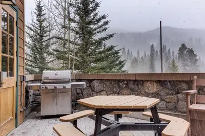 a wooden picnic table and a grill on a patio at Arap Ldg 8101 in Keystone