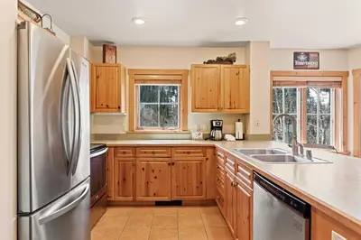 a kitchen with wooden cabinets and a stainless steel refrigerator at Expedition Station 8603 in Keystone