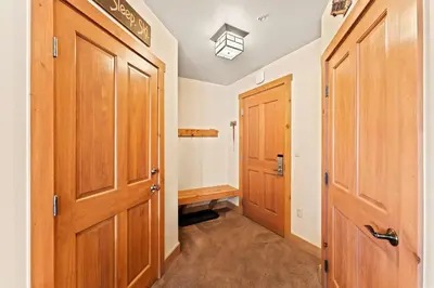 a hallway with two wooden doors and a bench at Expedition Station 8603 in Keystone