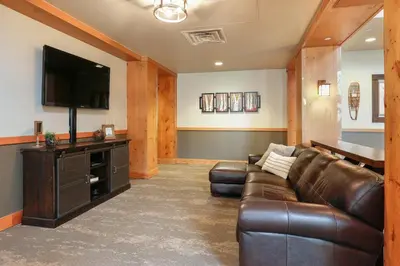 a living room with a leather couch and a flat screen tv at Expedition Station 8603 in Keystone