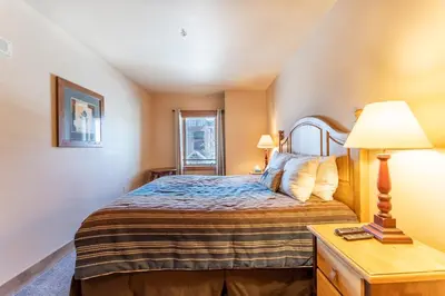 a bedroom with a bed and a table with a lamp at Red Hawk Lodge 2271 : 300 in Keystone