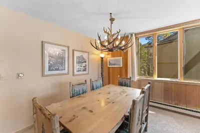 a dining room with a wooden table and a chandelier at Pines 2166 in Keystone