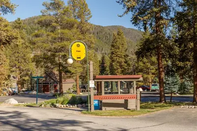 a yellow sign in front of a bus stop at Pines 2166 in Keystone