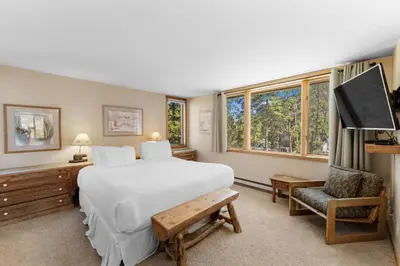 a bedroom with a large white bed and a chair at Pines 2166 in Keystone