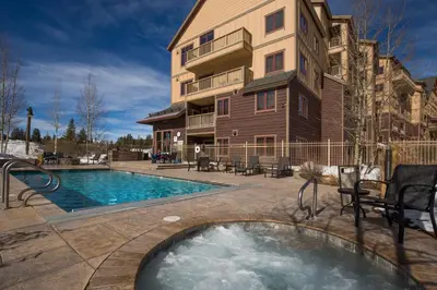 a house with a swimming pool next to a building at Red Hawk Lodge 2313 in Keystone