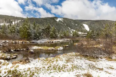 a river in the mountains with snow on the ground at Gateway 5053 in Keystone