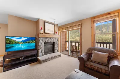 a living room with a television and a fireplace at Buffalo Lodge 8391 in Keystone