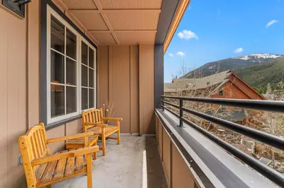 two wooden benches sitting on the balcony of a house at Dakota Lodge 8512 in Keystone
