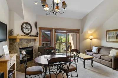 a living room with a table and a fireplace at Red Hawk Lodge 2312 in Keystone