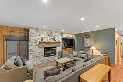 a living room with couches and a stone fireplace at Chateaux DuMont 2723 in Keystone