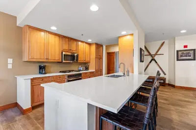 a kitchen with a white counter top and wooden cabinets at Timbers 3073: 2250 in Keystone