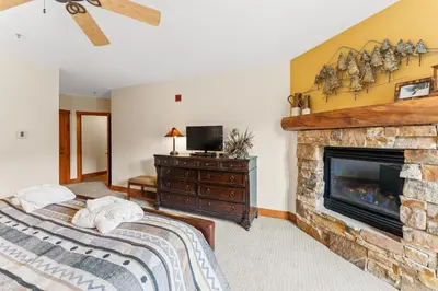 a bedroom with a bed and a fireplace at Timbers 3073: 2250 in Keystone