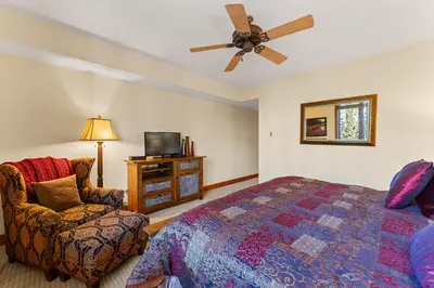 a bedroom with a bed and a chair and a ceiling fan at Timbers 3073: 2250 in Keystone