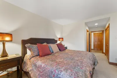 a bedroom with a bed and a table with a lamp at Timbers 3073: 2250 in Keystone