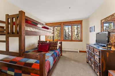 a bedroom with a bunk bed and a tv at Timbers 3073: 2250 in Keystone