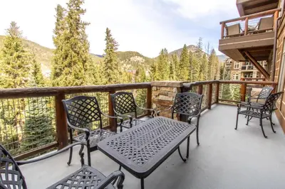 a balcony with chairs and a table with a view at Timbers 3073: 2250 in Keystone