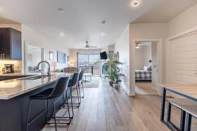 a kitchen and living room with a counter and chairs at Sail Lofts 303 in Dillon