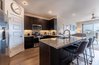 a kitchen with a sink and a counter with bar stools at Sail Lofts 303 in Dillon