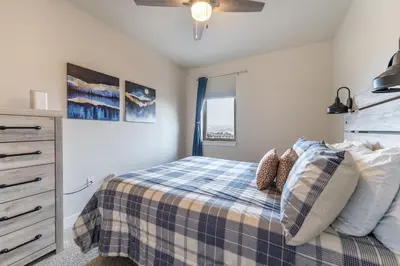 a bedroom with a bed with a blue and white blanket at Sail Lofts 303 in Dillon