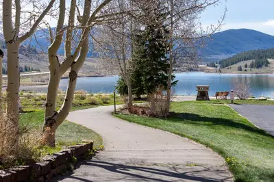 a walking path next to a lake with a bench at Sail Lofts 303 in Dillon