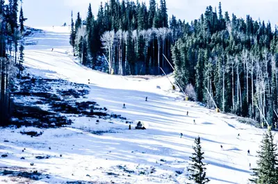 a group of people skiing down a snow covered slope at Saints John 2500 in Keystone