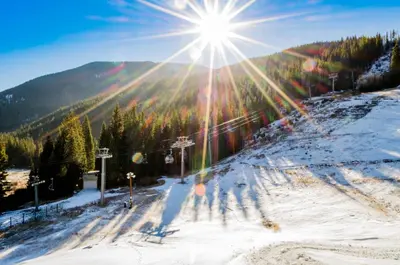 a sun is shining on a snow covered ski slope at Saints John 2500 in Keystone