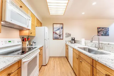 a kitchen with white appliances and wooden cabinets at Ski Run 412 in Keystone