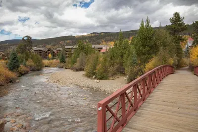 a wooden bridge over a river with a town in the background at Ski Run 412 in Keystone