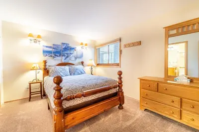 a bedroom with a wooden bed and a dresser at Buffalo Ridge Village 314G in Silverthorne