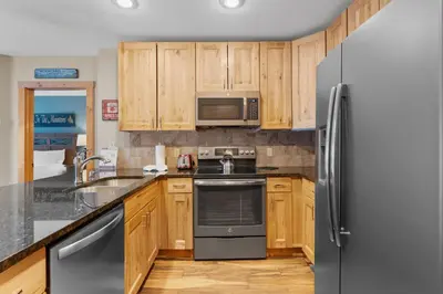 a kitchen with wooden cabinets and a stainless steel refrigerator at Expedition Station 8571 in Keystone