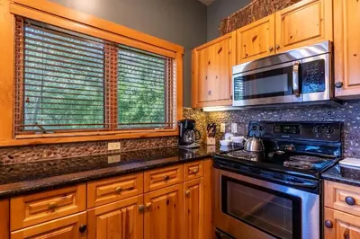 a kitchen with wooden cabinets and a stove and microwave at Expedition Station 8568 in Keystone