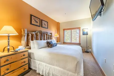 a bedroom with a bed and a dresser and a television at Expedition Station 8568 in Keystone