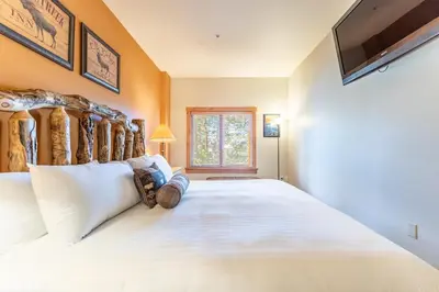 a bedroom with a large white bed and a television at Expedition Station 8568 in Keystone