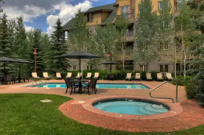 a pool with a table and chairs next to a building at Expedition Station 8568 in Keystone