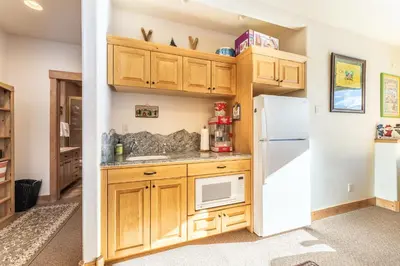 a kitchen with wooden cabinets and a white refrigerator at 94 Ryan Gulch Road in Silverthorne