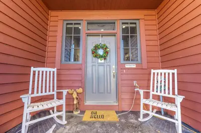 two chairs sitting outside of a red house with a door at 94 Ryan Gulch Road in Silverthorne