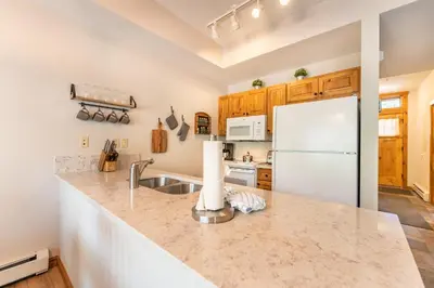 a kitchen with a sink and a refrigerator at Seasons at Keystone 1836 in Keystone