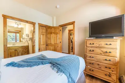 a bedroom with a bed with a tv and a dresser at Seasons at Keystone 1836 in Keystone