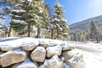 a snow covered rock wall in front of a sign at Seasons at Keystone 1836 in Keystone
