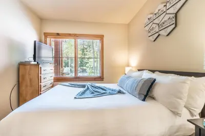 a bedroom with a white bed with a television on it at Seasons at Keystone 1836 in Keystone